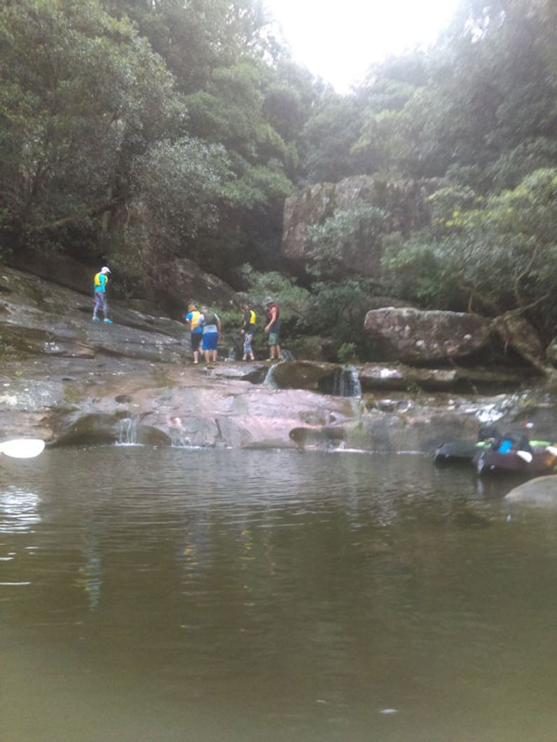 Kayakers climbing waterfall