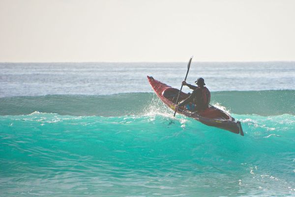 Kayaking over wave in the ocean at Terrigal Beach, Central Coast